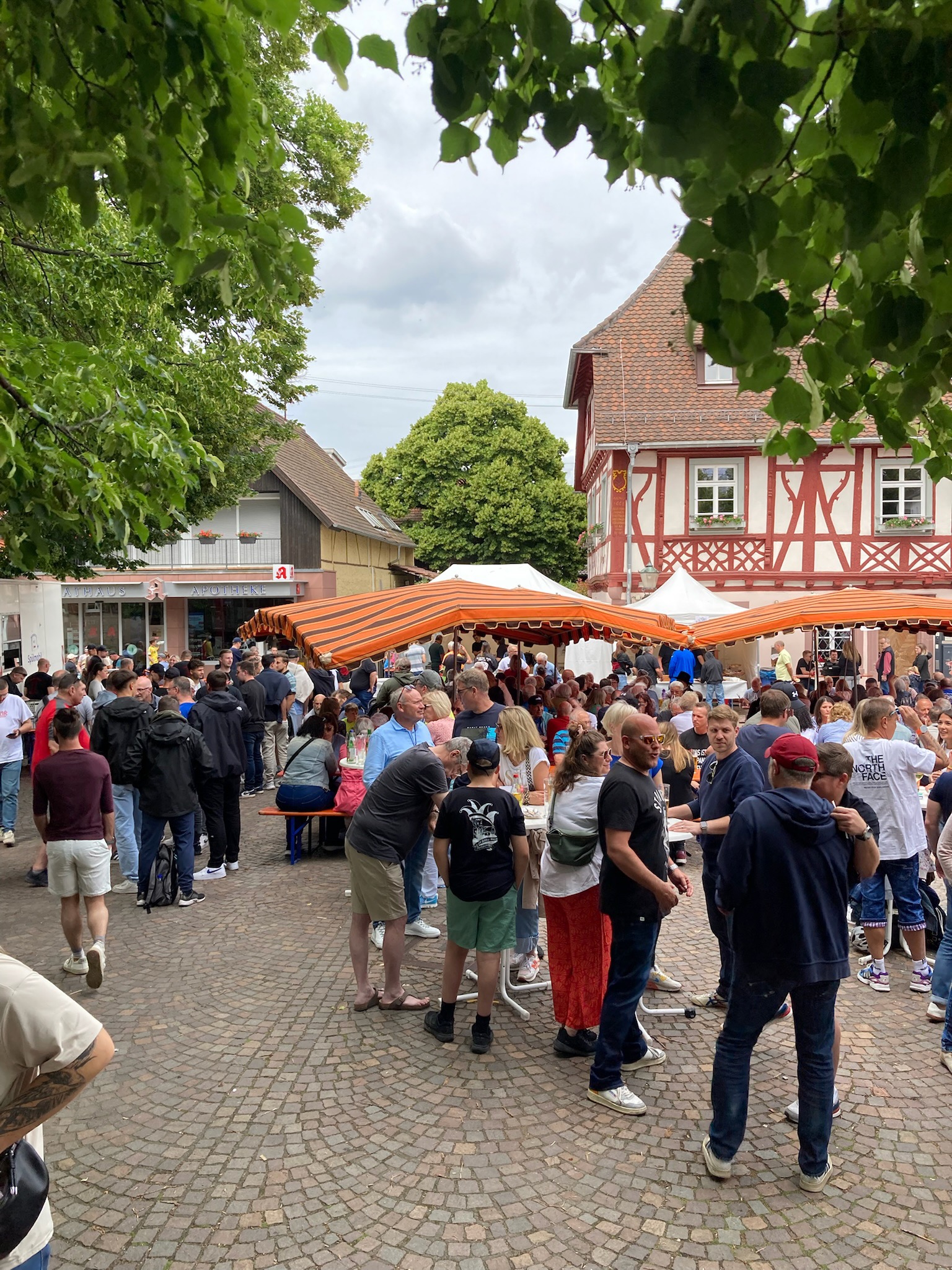 Menschen in geselliger Runde auf dem Rathausplatz beim Weinmarkt Grötzingen