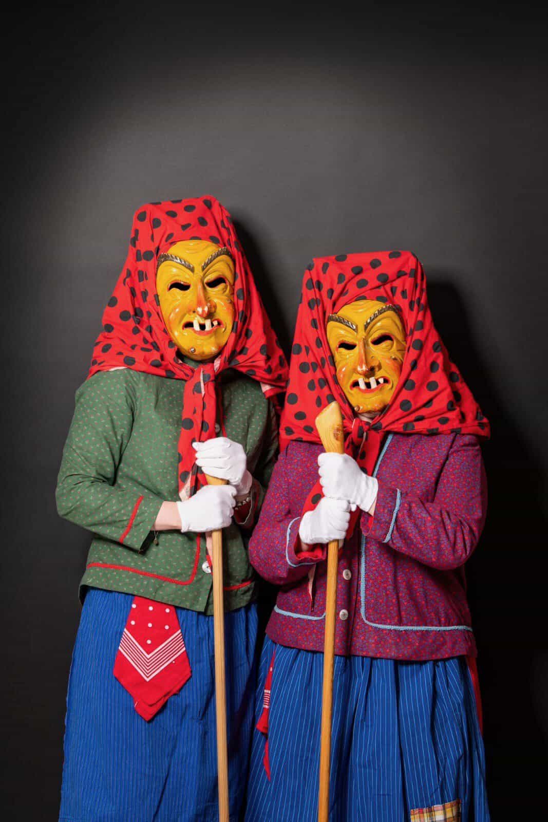 Zwei Hottscheck Hexen in traditionellem Häs, eine im grünen und eine im roten Peter, bei der Grötzinger Fasenacht